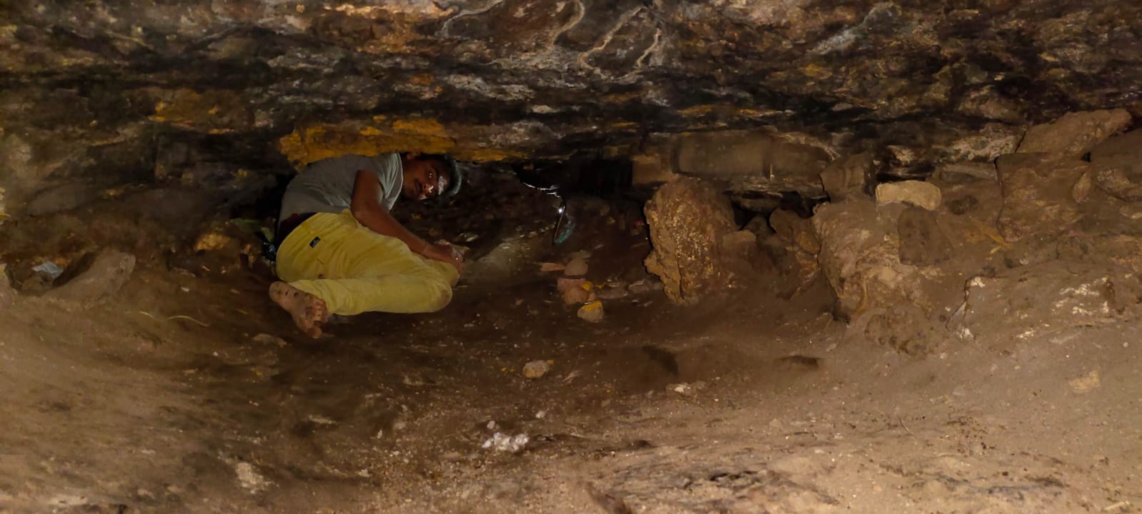 Devotee crawling through the narrow cave passage
